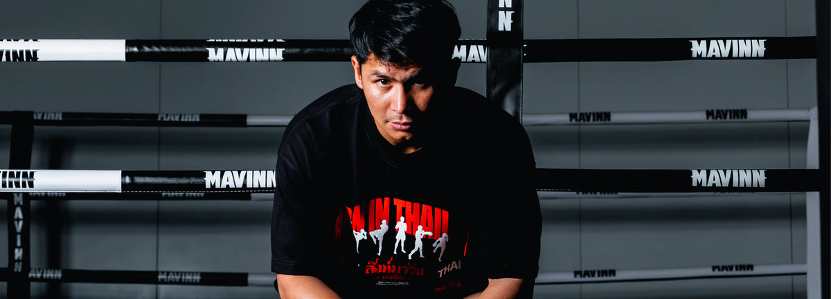 Man wearing a black MAVINN Muay Thai graphic tee in the store